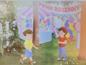 Na ilustracji widać scenę z pikniku rodzinnego. W tle stoi duży namiot z różowo-białym daszkiem i napisem „PIKNIK RODZINNY”. Pod namiotem znajdują się stoiska z kolorowymi balonami i słodyczami, a wokół widać kilka osób, które spacerują i rozmawiają.

Na pierwszym planie są dwaj chłopcy. Jeden z nich ma żółtą koszulkę, niebieskie spodenki i czerwone buty, a drugi czerwoną koszulkę, niebieskie spodnie i białe buty. Wygląda na to, że dobrze się bawią – jeden z nich macha ręką, jakby witał kolegę lub zapraszał go do wspólnej zabawy.

Cała scena jest pogodna i kolorowa, pełna radości i rodzinnej atmosfery. Wokół rosną drzewa i trawa, co podkreśla, że piknik odbywa się na świeżym powietrzu.