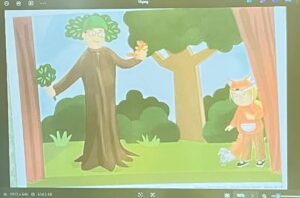 Na tym obrazku widzę ilustrację przedstawiającą scenę w lesie lub parku:

Postacie:

Osoba dorosła po lewej stronie - ubrana w długi brązowy płaszcz lub szatę przypominającą strój drzewa, z zielonymi, bujnymi włosami stylizowanymi jak korona drzewa, w okularach, trzymająca pomarańczowego lisa/lisią maskotkę
Dziecko po prawej stronie - ubrane w pomarańczowy strój lisa z białymi elementami (brzuszek, ogon), w masce lisa na głowie, stojące przy pniu drzewa
Otoczenie:

Duże drzewo w centrum z żółto-brązowym pniem i bujną zieloną koroną
Pnie drzew po bokach ilustracji (po lewej i prawej)
Zielone krzewy i trawa w tle
Jasne, błękitne niebo
Biały królik siedzący na trawie w prawym dolnym rogu
Styl i atmosfera:
Ilustracja wykonana w delikatnym, akwarelowym stylu z pastelowymi kolorami. Scena ma charakter baśniowy i teatralny - wygląda na przedstawienie lub zabawę tematyczną związaną z lasem i zwierzętami. Osoba dorosła jest przebrana za drzewo, a dziecko za lisa, co sugeruje edukacyjną lub teatralną aktywność dla dzieci. Atmosfera jest radosna, kolorowa i pełna wyobraźni.